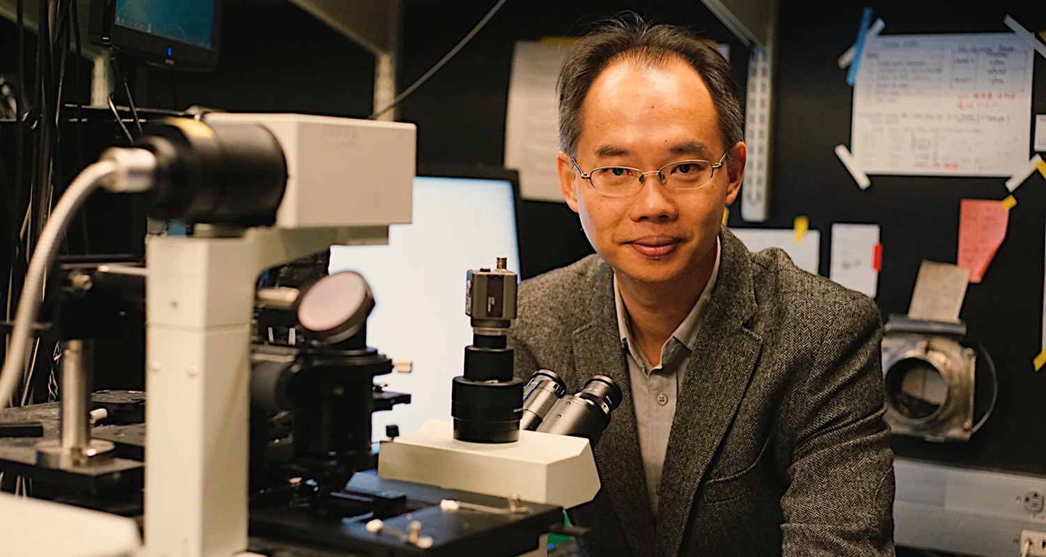Wei Min winner of the SPIE Biophotonics Technology Award with a microscope