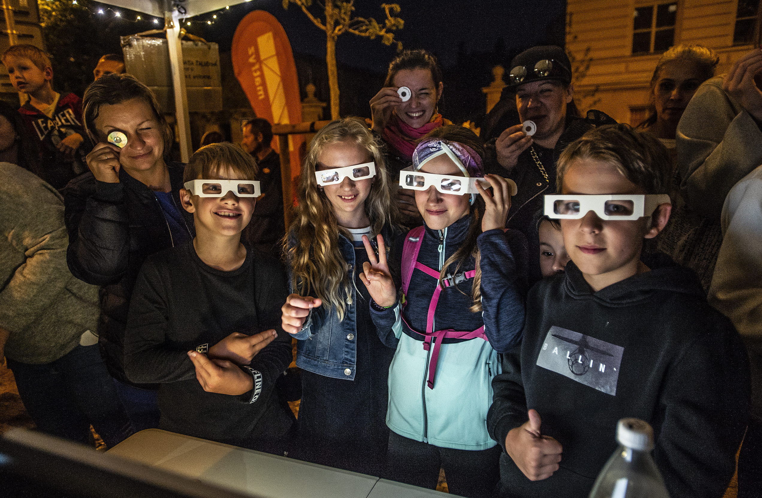 Five children wear diffraction glasses to participate in an outreach event.