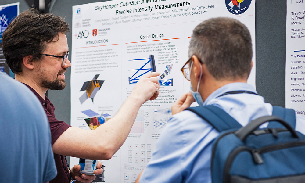 A woman shows her poster presentation at Astronomical Telescopes + Instrumentation