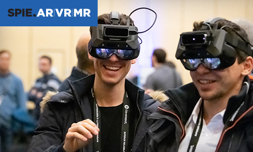 Two men excitedly try out virtual reality headsets at SPIE AR VR MR