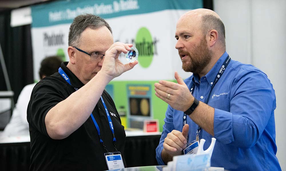 An attendee interacts with an exhibitor at an SPIE event