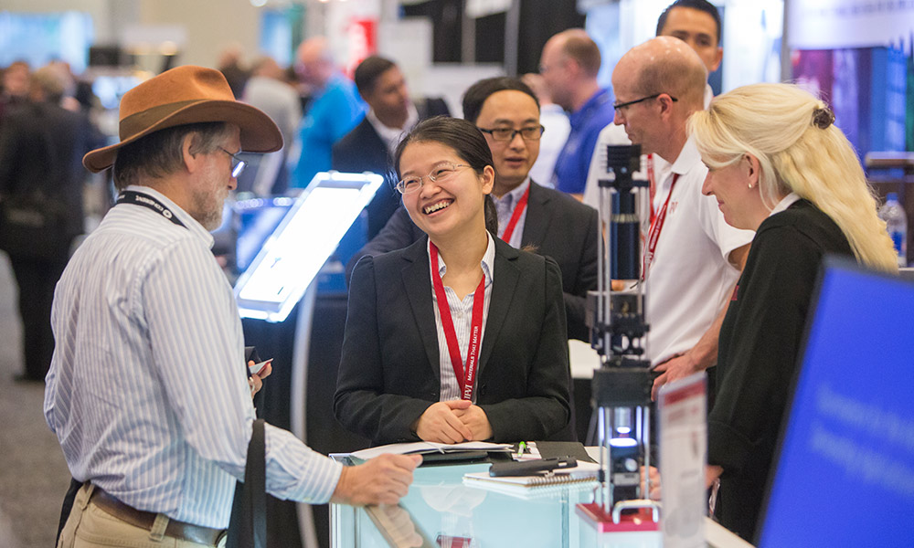 Male attendee talks with a vendor at Photonics West