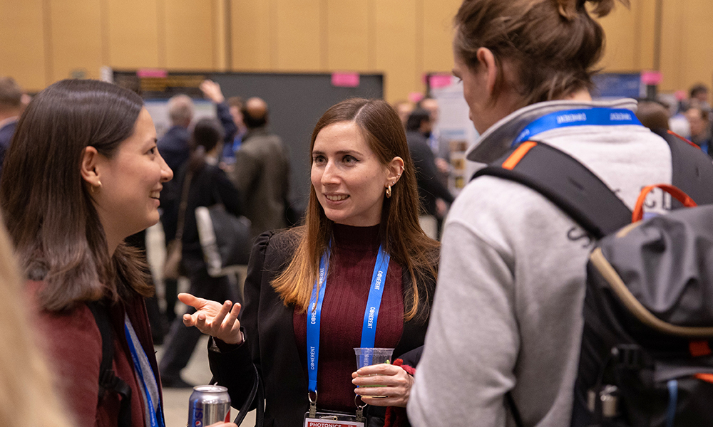 Three females and one male gather in conversation at SPIE Photonics West