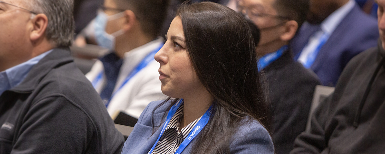 Audience listens to a speaker present from the podium