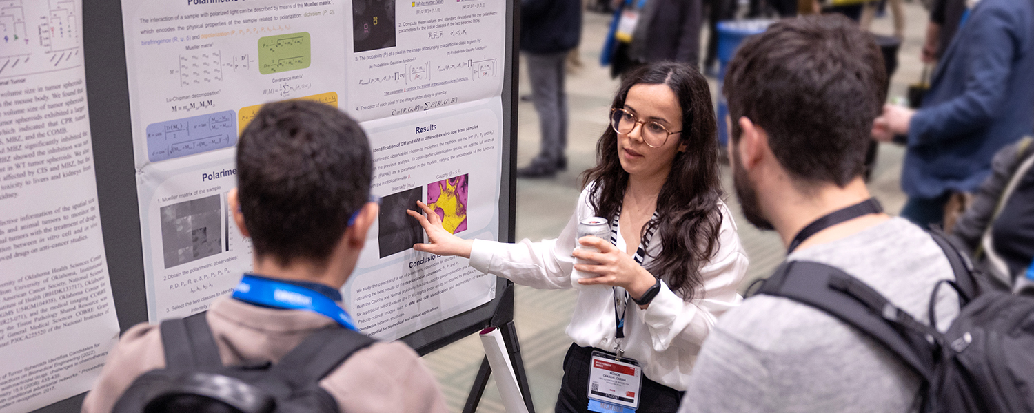 Attendees of SPIE AR | VR | MR discuss research points at a poster session