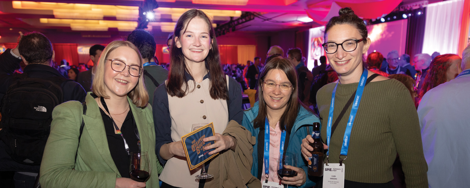 Four people stand together and enjoy the Welcome Reception at Photonics West