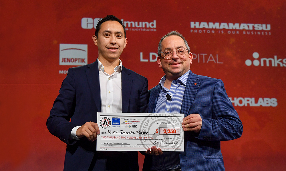 Two people holding giant check for Startup Challenge prize money
