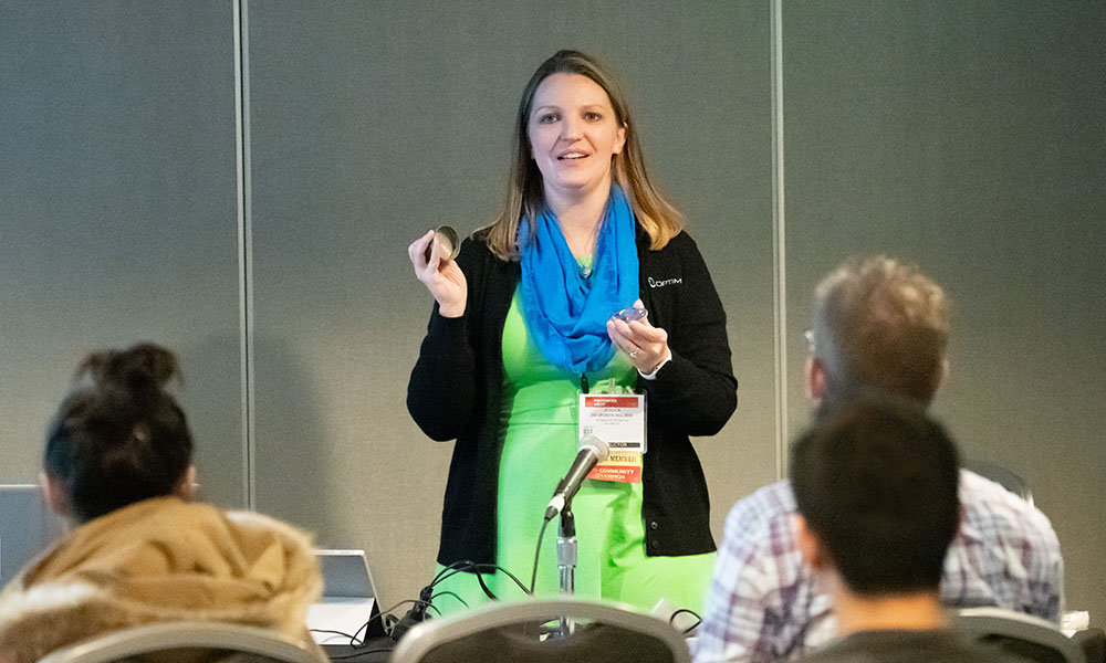 Woman at the front of a classroom teaches a course on optics