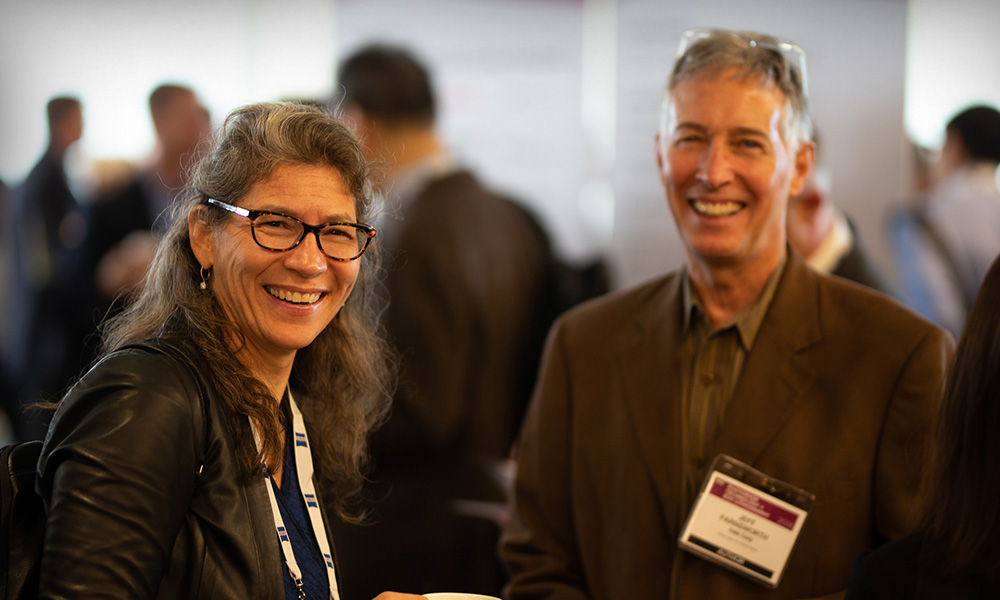 Two BACUS members smiling and networking at an SPIE event