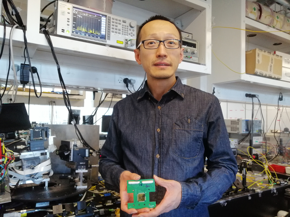 Hao Hu (Technical University of Denmark)  holding his experimental integrated optical phased array