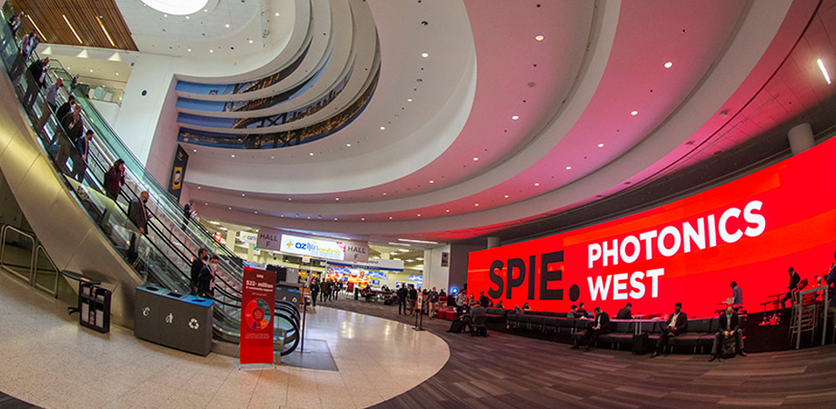 Digital SPIE Photonics West sign in sweeping Moscone Center hallway.
